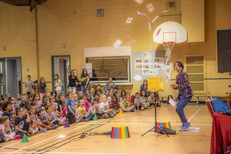 Tour de magie de carte qui vole avec publique d'école primaire